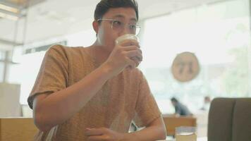 A young man drinks coffee at a relaxed cafe. video