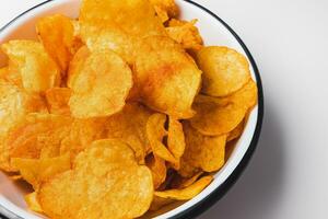 ahumado pimenton patata papas fritas en cuenco en blanco antecedentes. rápido alimento, basura comida y insalubre meriendas concepto, de cerca foto