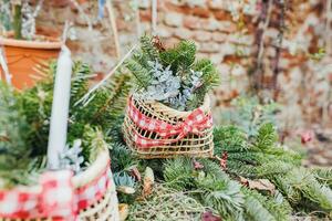 natural bricolaje al aire libre Navidad decoración en jardín. pino ramas en Paja cesta. ambiente, reciclar, reutilizar y cero residuos concepto. selectivo enfocar, atención espacio foto