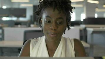 negro mujer empleado sonrisas como ella lee correo electrónico video