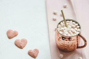 Heart cookies and hot cocoa with marshmallows on a white and pink backround. Valentine's Day and winter concept. Selective focus, copy space. photo