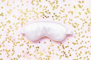 Pink satin eye sleeping mask and golden stars photo