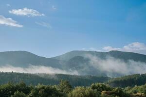 Morning in the mountains, rising fog on the mountain slope, dense forests and parks in Bulgaria photo