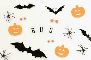 Pumpkins, spiders, bats and text BOO on white background. Halloween flat layout, holiday concept photo