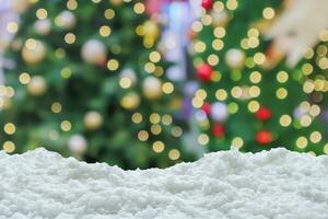 Empty white snow with blur Christmas tree with bokeh light background photo