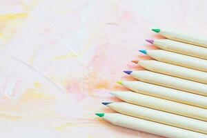 Multicolored pencils on pink background photo