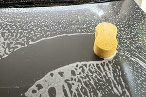 coche limpieza y Lavado con amarillo esponja y espuma jabón foto