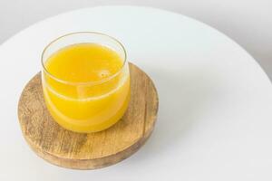 Fresh squeezed orange juice in glass on table on white background. Healthy beverage for breakfast photo