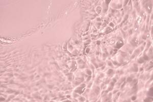 Abstract transparent water shadow surface texture natural ripple on pink background photo