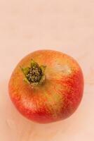 One red ripe pomegranate on a pink background. Selective focus, copy space. photo