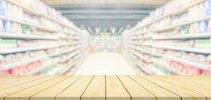 Wood table top with supermarket grocery store blurred background photo