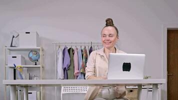 A boy giving a greeting card and gift to a woman working with laptop video