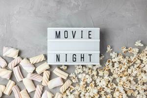 Text MOVIE NIGHT with popcorn and marshmallow. Movie snacks photo
