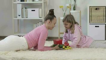 a woman laying on the floor reading a book and a girl coming with a gift video