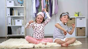 zwei Kinder Sitzung auf ein Teppich im ein Zimmer video