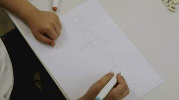 a child writing on a piece of paper with a marker video