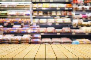 Empty wood table top with blur meat shelves in supermarket background for product display photo