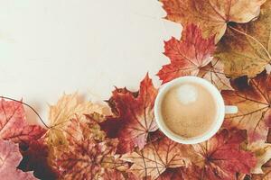 Cup of espresso with crema and autumn red maple leaves on white background. Fall season mood, flat lay. Top view, copy space photo