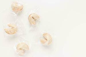 Fresh and tasty Chinese fortune cookies, individually wrapped in foil on white background. Top view, copy space photo