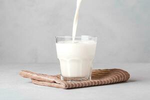 A stream of milk pours into a glass of milk. Healthy food. photo