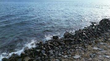 antenne visie van kiezelsteen strand met blauw zee video