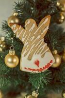 Christmas gingerbread angel on the background of a Christmas tree with golden balls photo