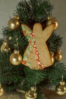 Navidad pan de jengibre ángel en el antecedentes de un Navidad árbol con dorado pelotas foto