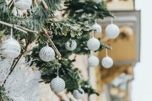 Christmas outdoor decoration on the building. Pine branches and classical Christmas balls in trendy white and silver colors. Street Christmas decoration concept photo