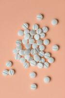 Pills on orange background, medical supplement concept photo