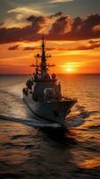 Sunset over a navy ship on the open sea photo