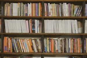 industrial oscuro de madera estantería lleno con social, ficción, yo mejora y biografía libros en un público biblioteca o un librero tienda. yogyakarta, Indonesia - 08 28 2023 foto