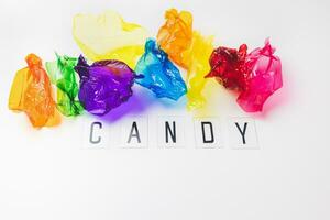 Colorful candy wrappers and text CANDY on white. Sugar sweets concept. Abstract colorful background with copy space photo