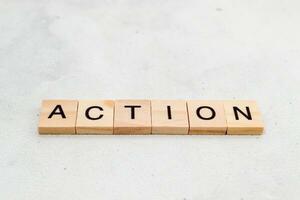 Top view of Action word on wooden cube letter block on white background. Business concept photo