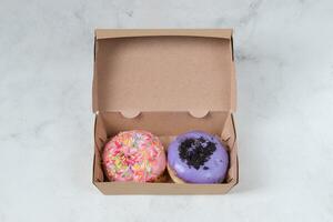 Delicious sweet donuts with different flavors in small paper box. Isolated image on white background photo