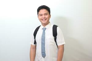 indonesio mayor alto colegio estudiante vistiendo blanco camisa uniforme con gris Corbata sonriente y mirando a cámara. aislado imagen en blanco antecedentes foto