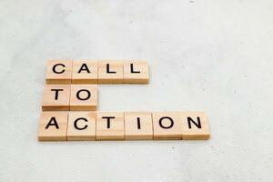 Top view of Call To Action word on wooden cube letter block on white background. Business concept photo