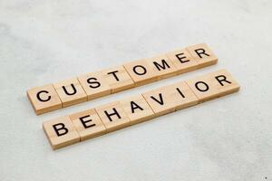 Top view of Customer Behavior word on wooden cube letter block on white background. Business concept photo
