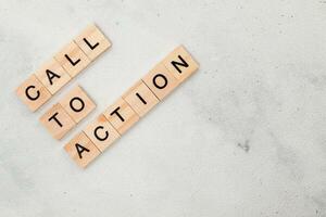 Top view of Call To Action word on wooden cube letter block on white background. Business concept photo