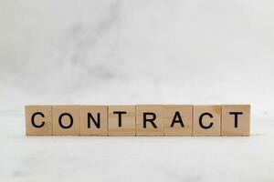 Top view of contract word on wooden cube letter block on white background. Business concept photo