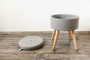 Trendy stool with and build-in storage. Side view, white wall, space for text photo
