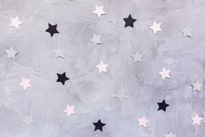 Paper confetti stars on gray background photo