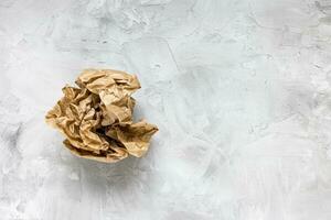 Crumpled brown kraft paper on gray background photo