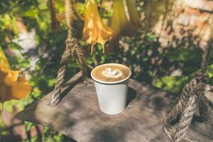 Coffee in eco friendly paper cup in autumn garden photo