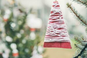 Red wool and paper handmade decoration on Christmas tree outdoor. Diy yarn crafts creative ideas for children. Environment, reuse, recycle, upcycling and zero waste concept. Selective focus photo