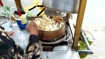 The tofu meatball, Bakso Tahu, seller who is serving buyers puts the tofu meatballs in plastic video