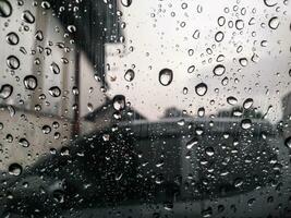 Rain drops on car windshield influence vehicle driving, storm weather forecast, rainy season photo