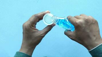hand hold a mouthwash liquid container video