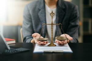 abogado masculino en la oficina con escala de latón sobre mesa de madera. concepto de justicia y derecho a la luz de la mañana foto