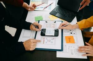 UX developer and ui designer brainstorming about mobile app interface wireframe design with customer breif and color code at modern office. photo