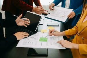 UX developer and ui designer brainstorming about mobile app interface wireframe design with customer breif and color code at modern office. photo